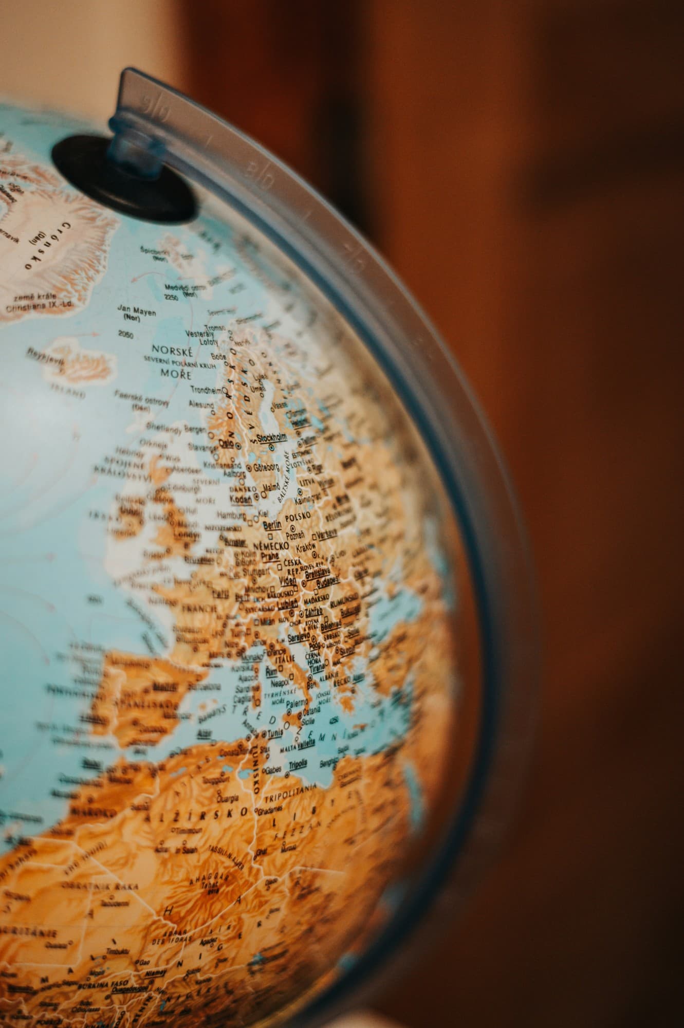 Globe terrestre coloré en gros plan, centré sur l'Europe et la Méditerranée, fond bois chaleureux